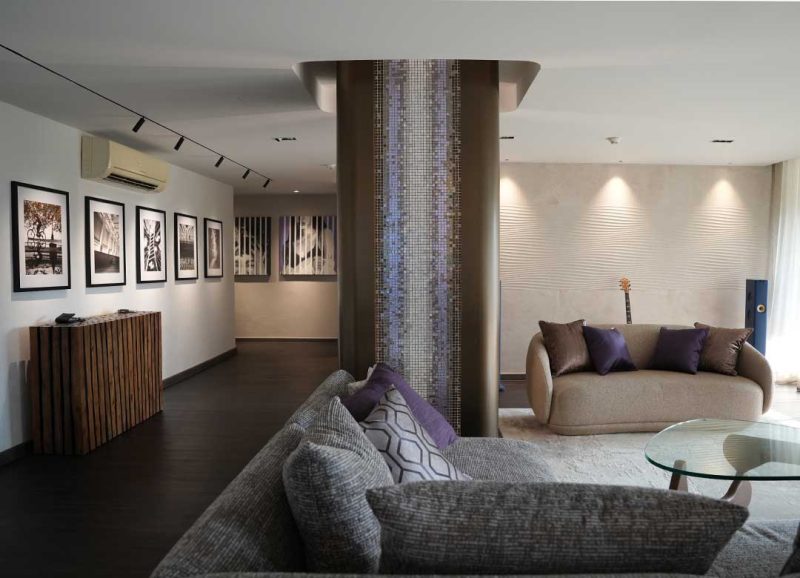 Bespoke turnkey condo renovation in Bangkok showcasing contemporary styling, a custom bronze steel column, and integrated lighting.