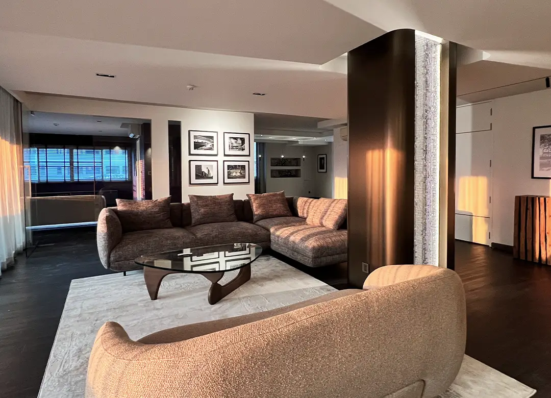 Luxury living room with curved sofa, Noguchi table, and custom curved bronze metal cladding integrated with SICIS glass mosaic column feature in Sathorn, designed by Elementi Interiors.