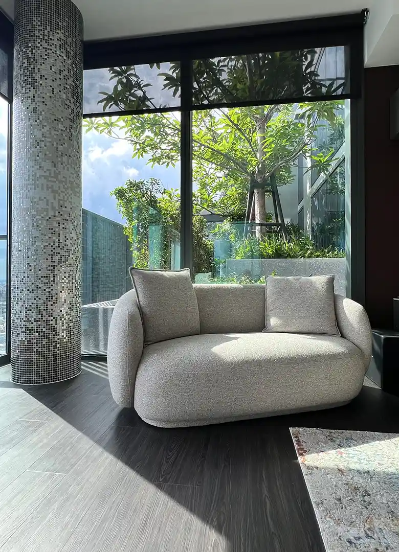 Custom rounded pillar clad in SICIS glass mosaic with curved armchair at Tait Sathorn 12 by Elementi Interiors